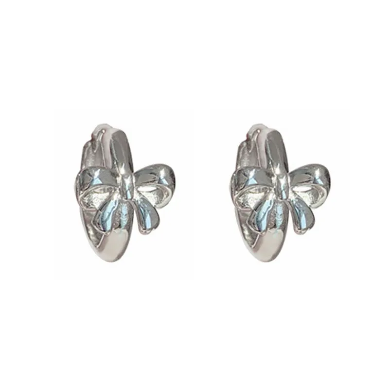 Pair of 925 sterling silver bow earrings with electroplated silver finish on white background