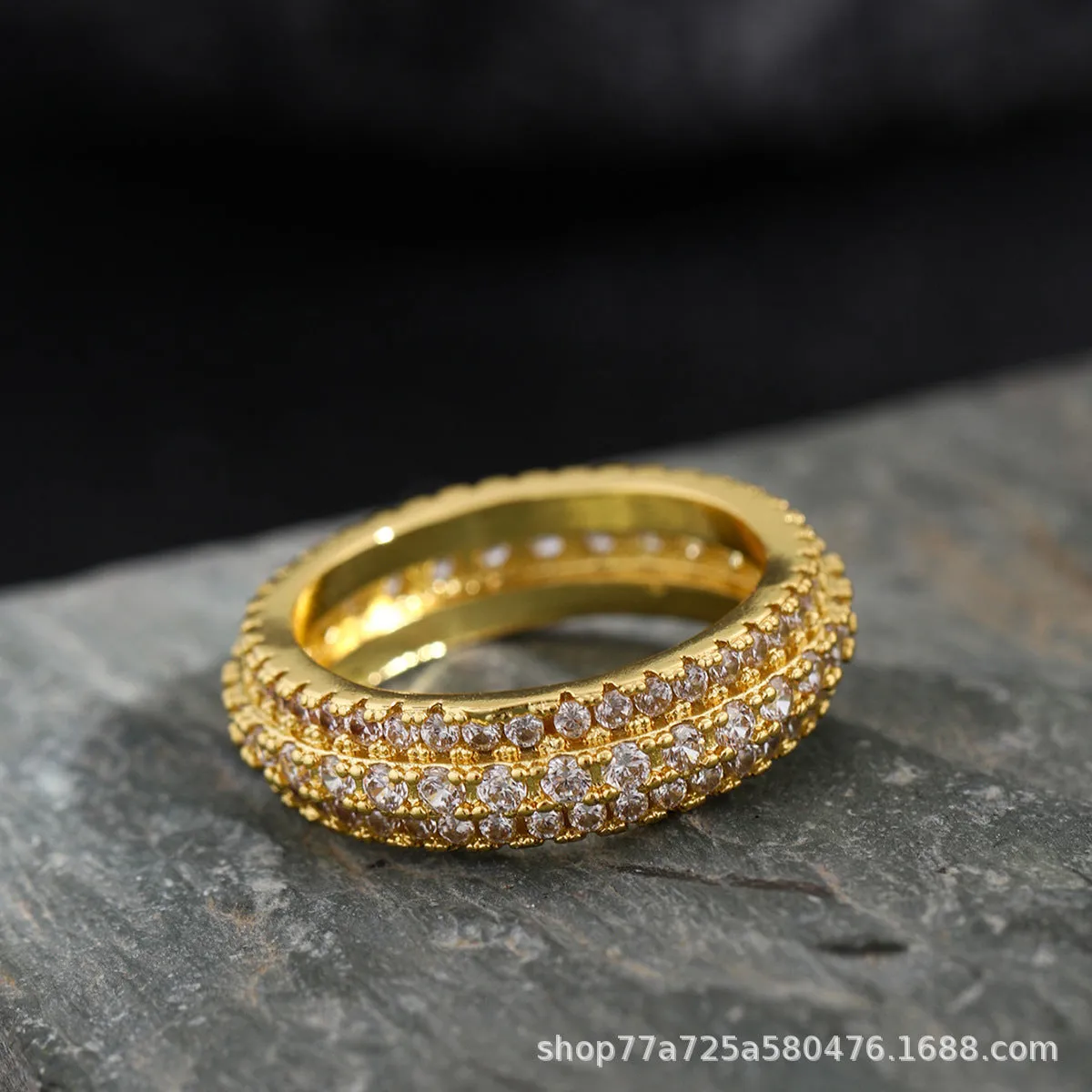 Geometric copper ring with a triangular zircon stone inlay, shown on a finger.