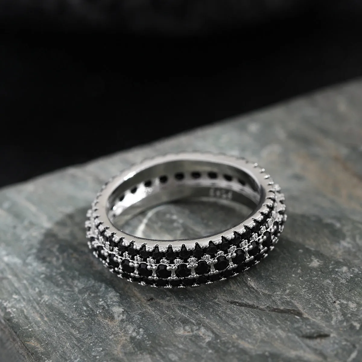 Geometric copper ring with a triangular zircon stone inlay, shown on a finger.