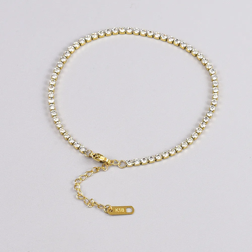 Gold titanium steel anklet with small fruit-shaped pendant and adjustable tail chain on bare ankle