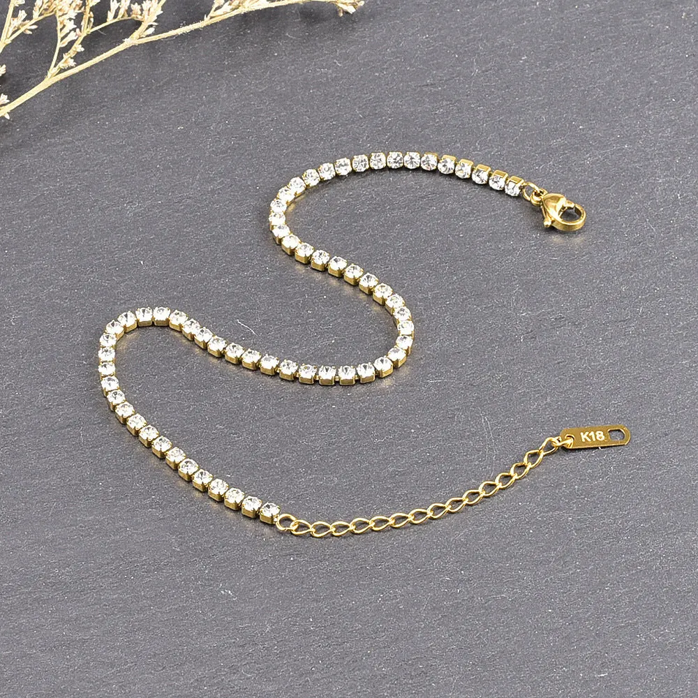 Gold titanium steel anklet with small fruit-shaped pendant and adjustable tail chain on bare ankle