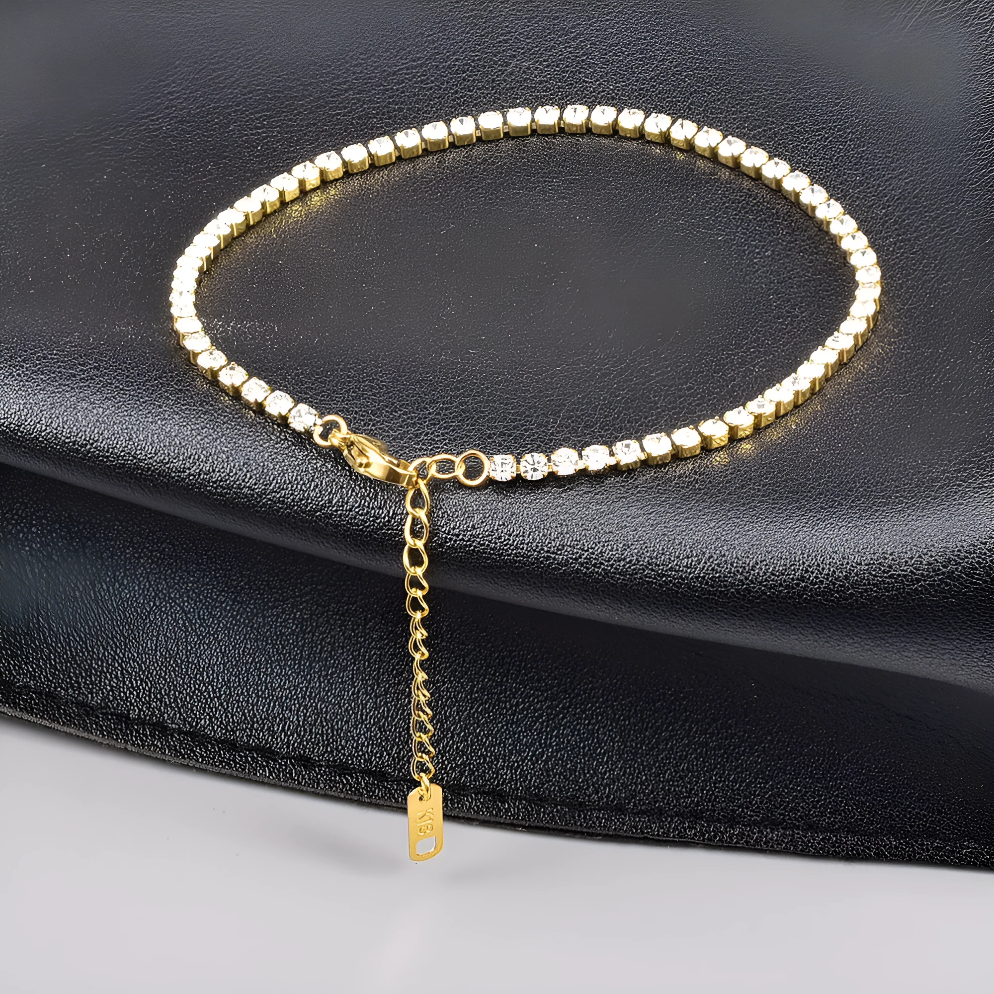Gold titanium steel anklet with small fruit-shaped pendant and adjustable tail chain on bare ankle