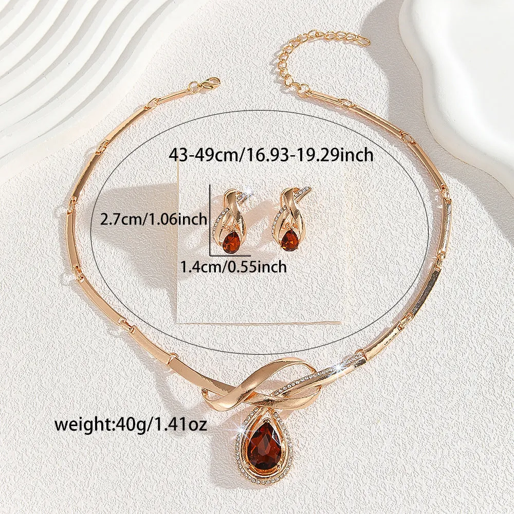 Gold alloy necklace and earrings suite with white rhinestone and brown crystal fan-shaped centrepiece on a white background