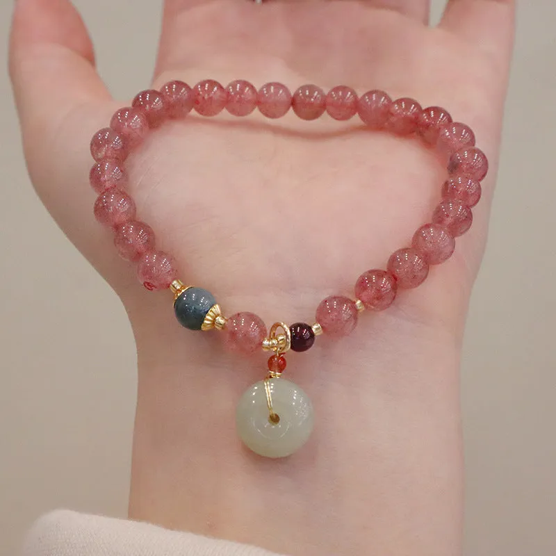 Women's strawberry quartz bracelet with geometric stones, purse charm and lucky bagg charm on wrist