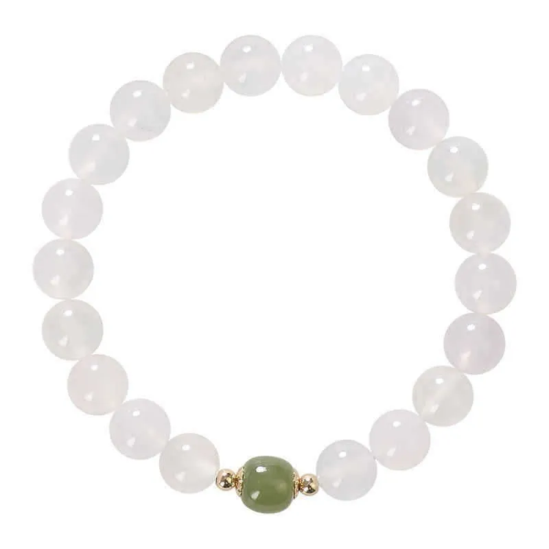 Handmade natural white agate and Hetian jade crystal bracelet with cinnabar inlay on a wrist.