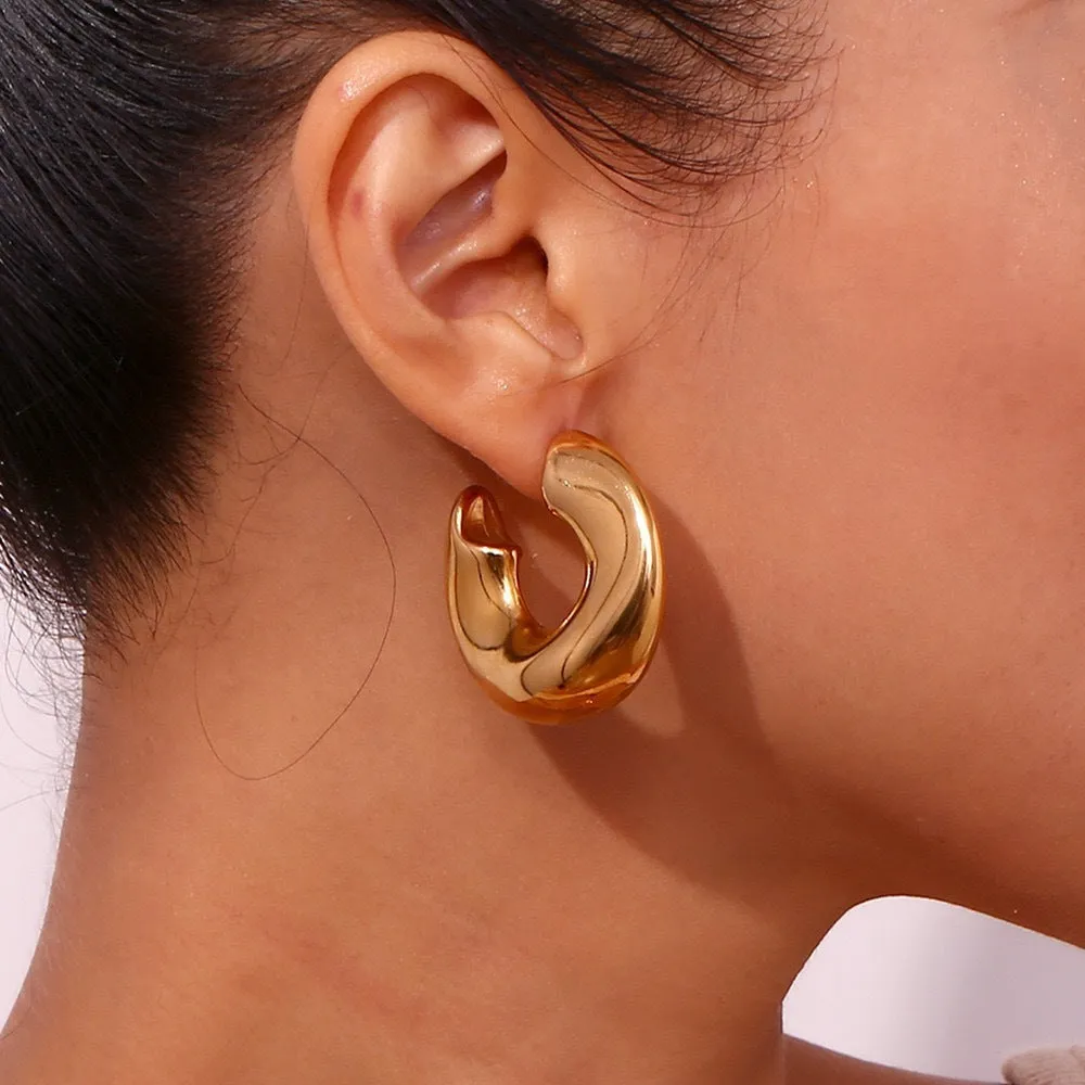 Gold and silver hollow irregular stainless steel earrings with geometric line design on white background