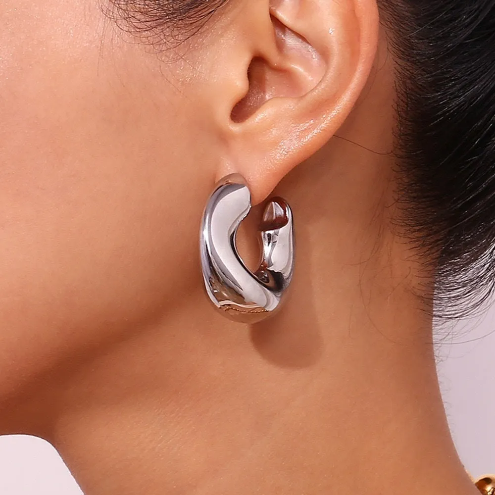 Gold and silver hollow irregular stainless steel earrings with geometric line design on white background