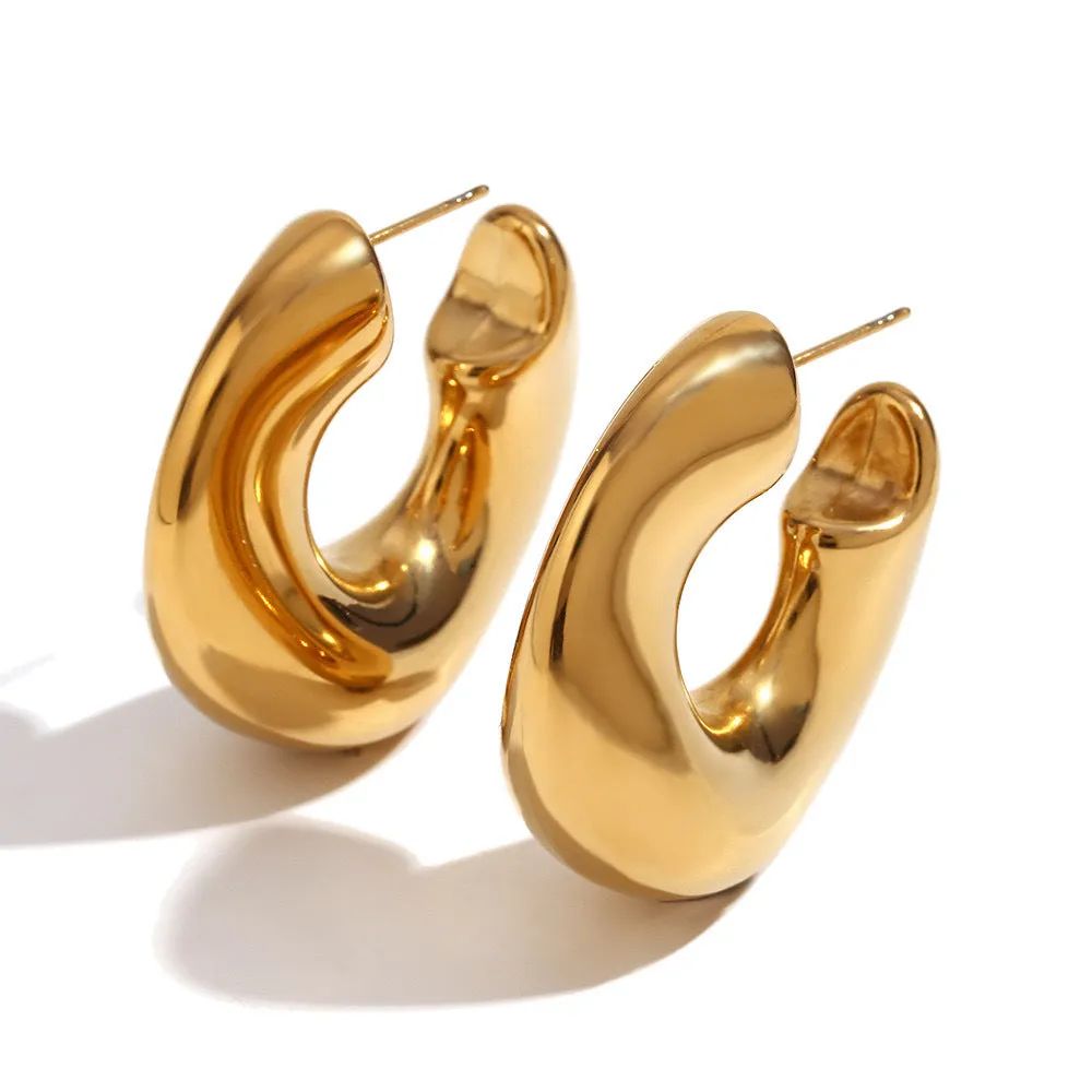 Gold and silver hollow irregular stainless steel earrings with geometric line design on white background
