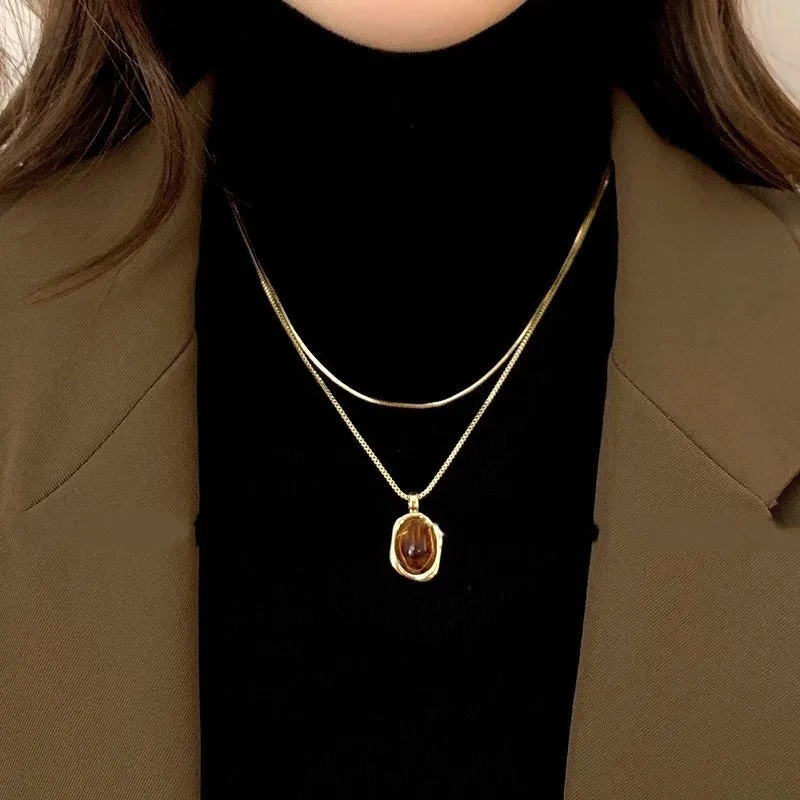 Women's geometric alloy pendant necklace with polished finish and gold copper clavicle chain on neutral background