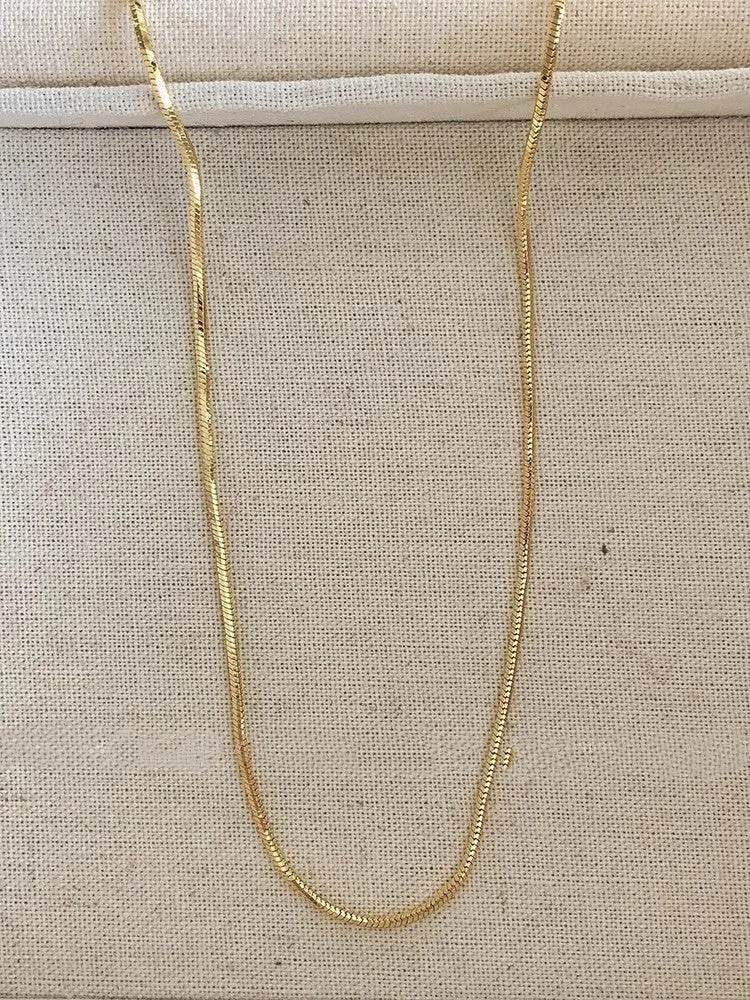 Women's geometric alloy pendant necklace with polished finish and gold copper clavicle chain on neutral background