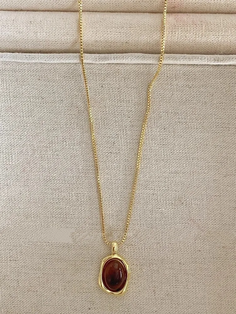 Women's geometric alloy pendant necklace with polished finish and gold copper clavicle chain on neutral background