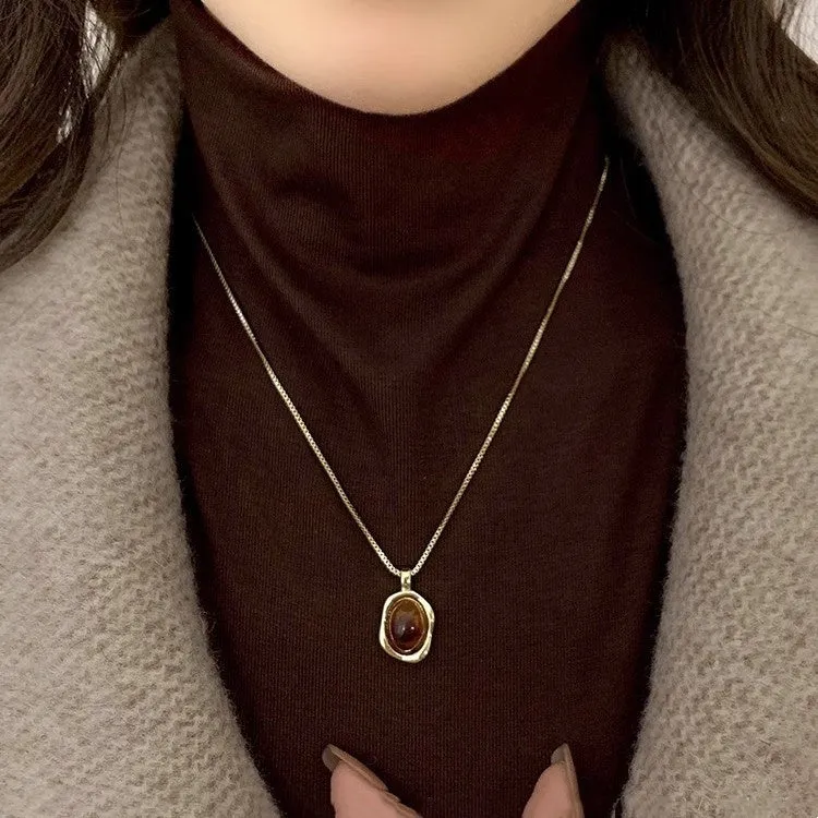Women's geometric alloy pendant necklace with polished finish and gold copper clavicle chain on neutral background