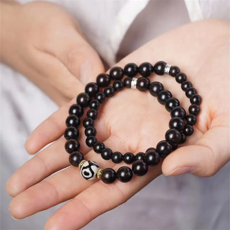 Dark ebony wood bracelet with 8mm Tibetan style beads showing two-circle pattern design