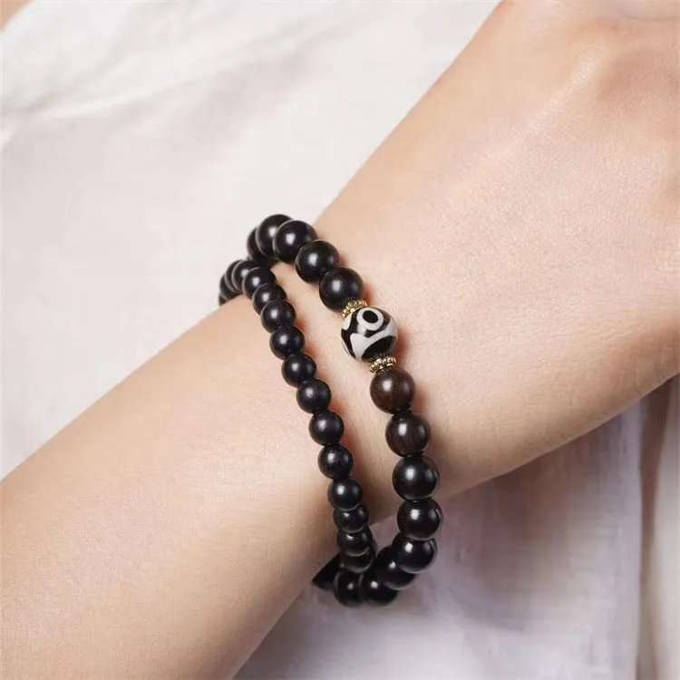 Dark ebony wood bracelet with 8mm Tibetan style beads showing two-circle pattern design