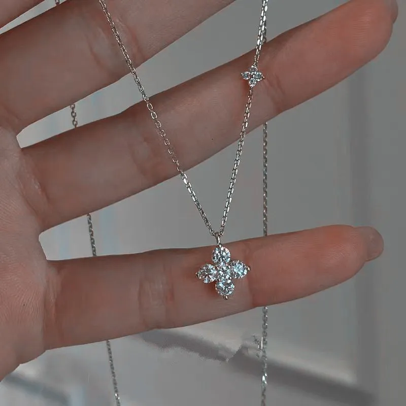Silver clover clavicle chain necklace with O-ring chain and flower pendant on white background