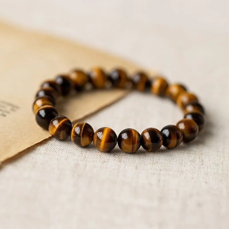 Tigereye Dzi bead single circle Buddha rosary bracelet on a wrist.