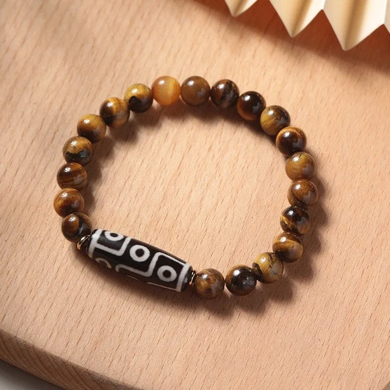 Tigereye Dzi bead single circle Buddha rosary bracelet on a wrist.