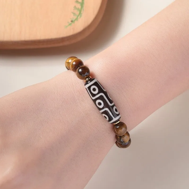 Tigereye Dzi bead single circle Buddha rosary bracelet on a wrist.
