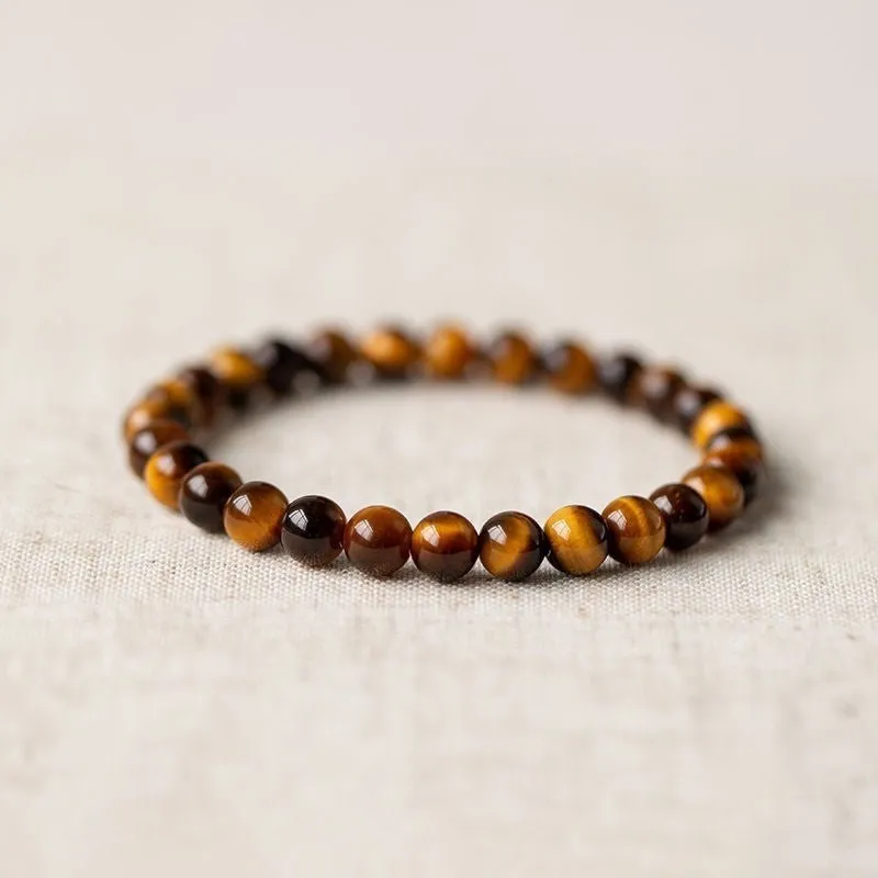 Tigereye Dzi bead single circle Buddha rosary bracelet on a wrist.