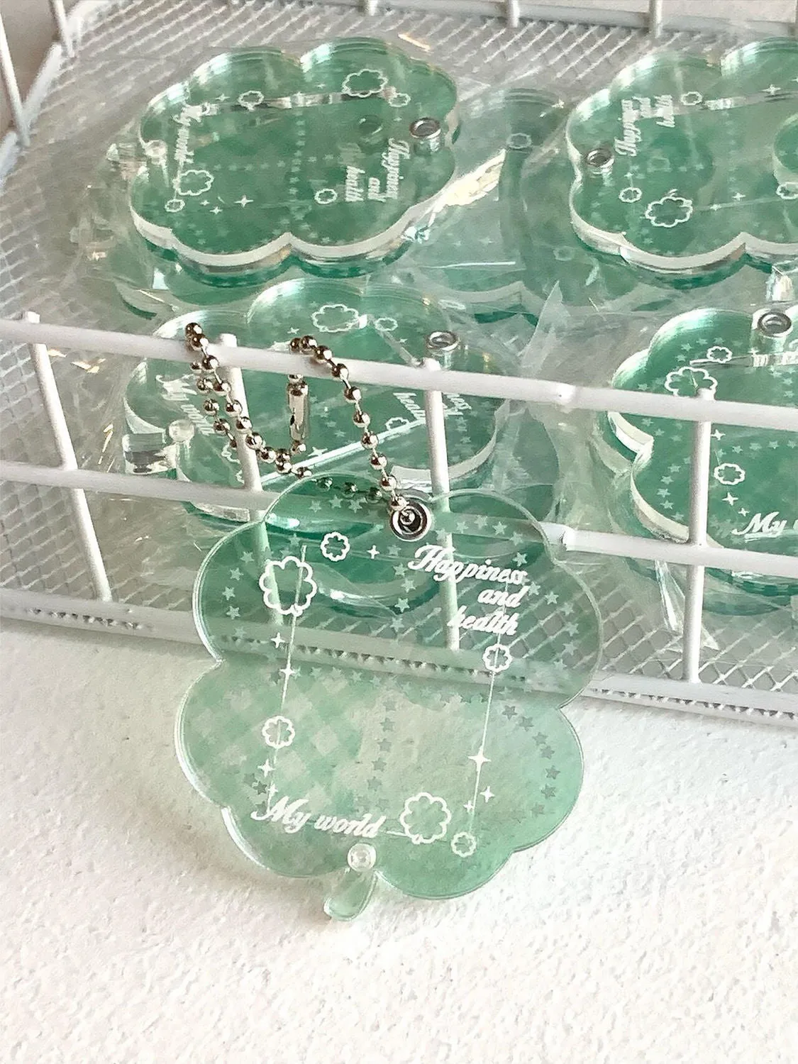 Acrylic four-leaf clover pendant keychain for phones in blue, green, and mint colour options.