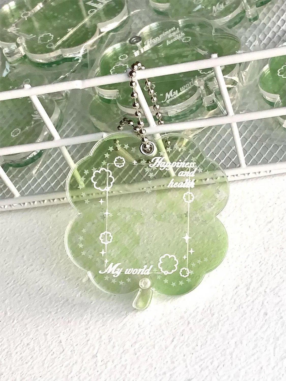 Acrylic four-leaf clover pendant keychain for phones in blue, green, and mint colour options.