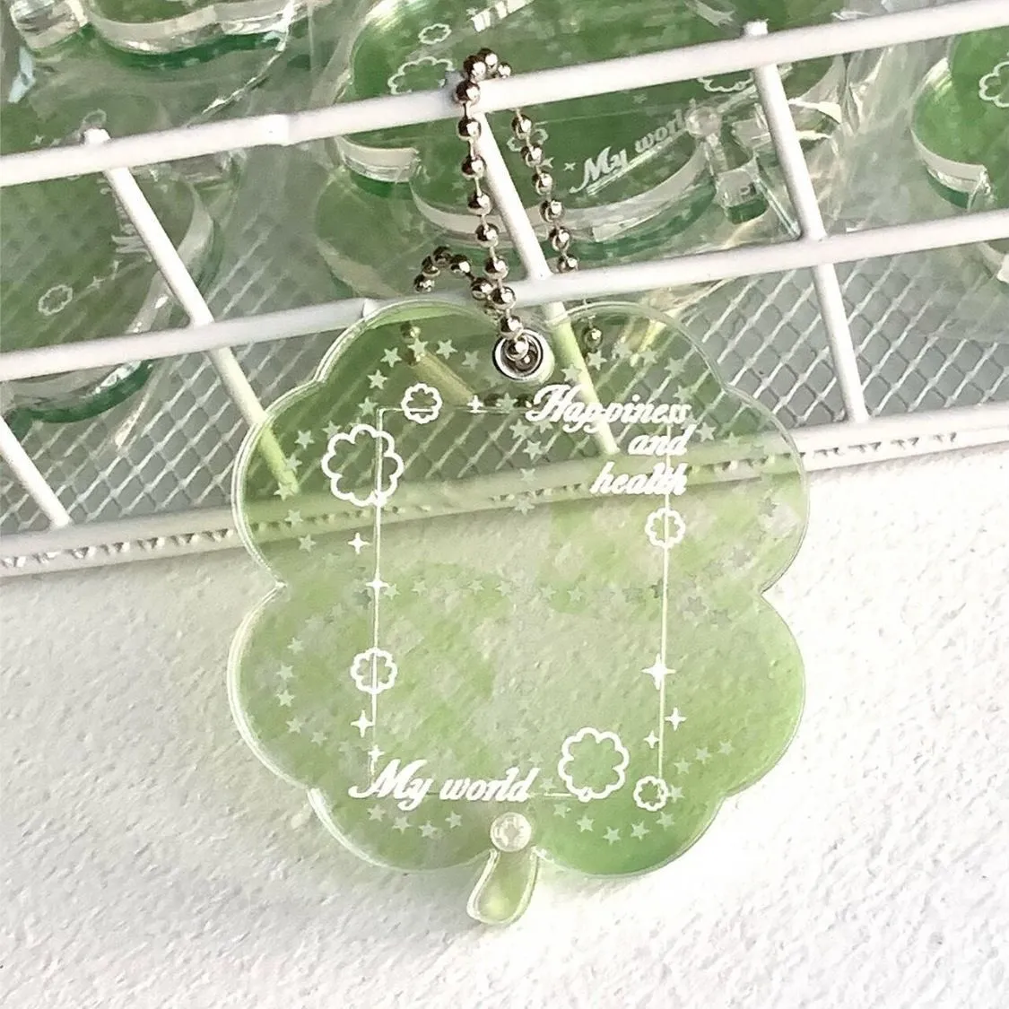 Acrylic four-leaf clover pendant keychain for phones in blue, green, and mint colour options.