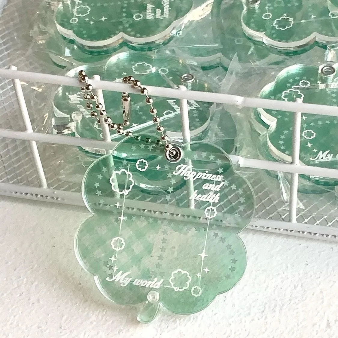 Acrylic four-leaf clover pendant keychain for phones in blue, green, and mint colour options.