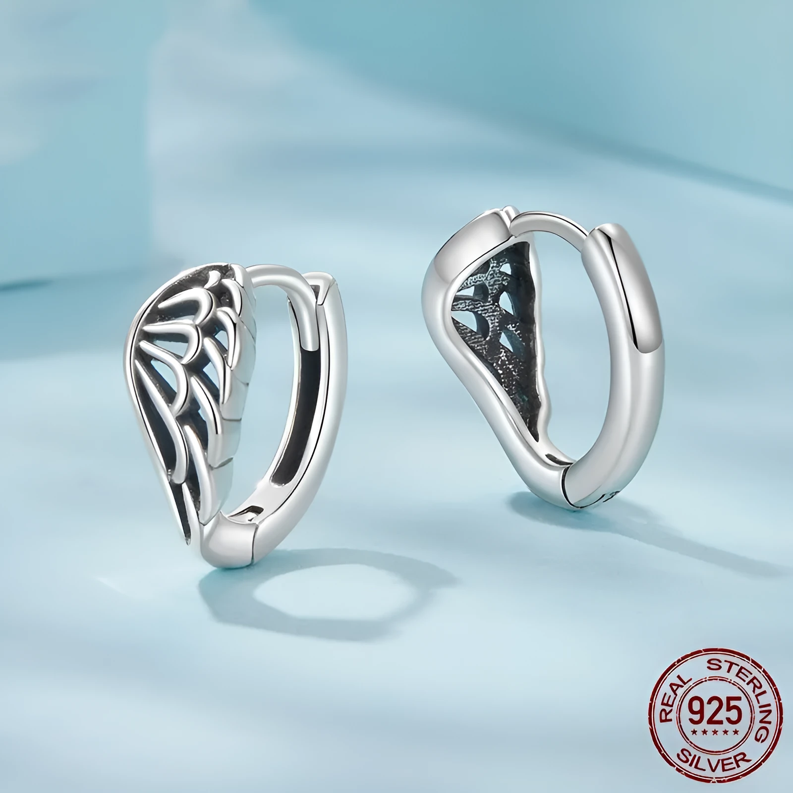 Pair of vintage S925 sterling silver wings ear clip earrings in silver colour on white background