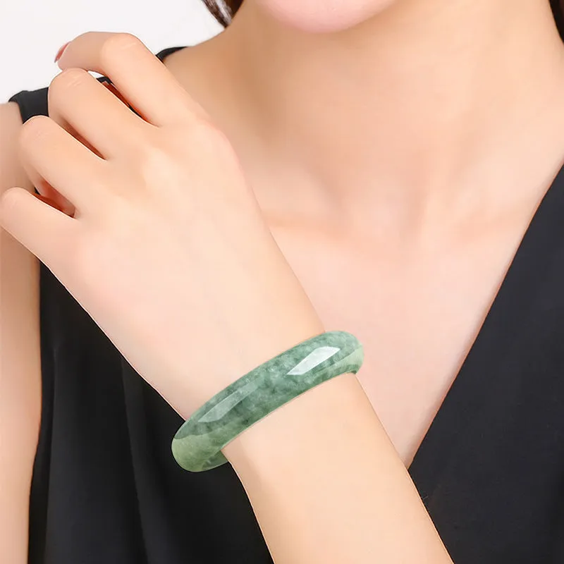 Natural deep pea green jade bangle bracelet for women on a gift box.