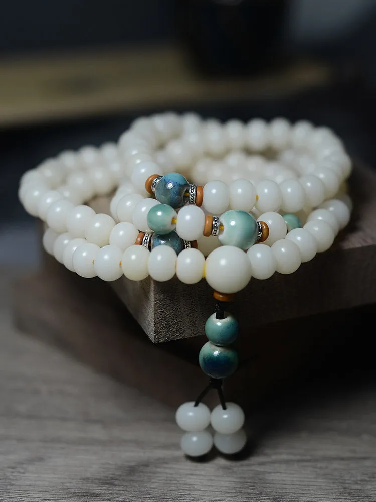White jade bodhi root bracelet with 108 flat round beads in two sizes on wrist