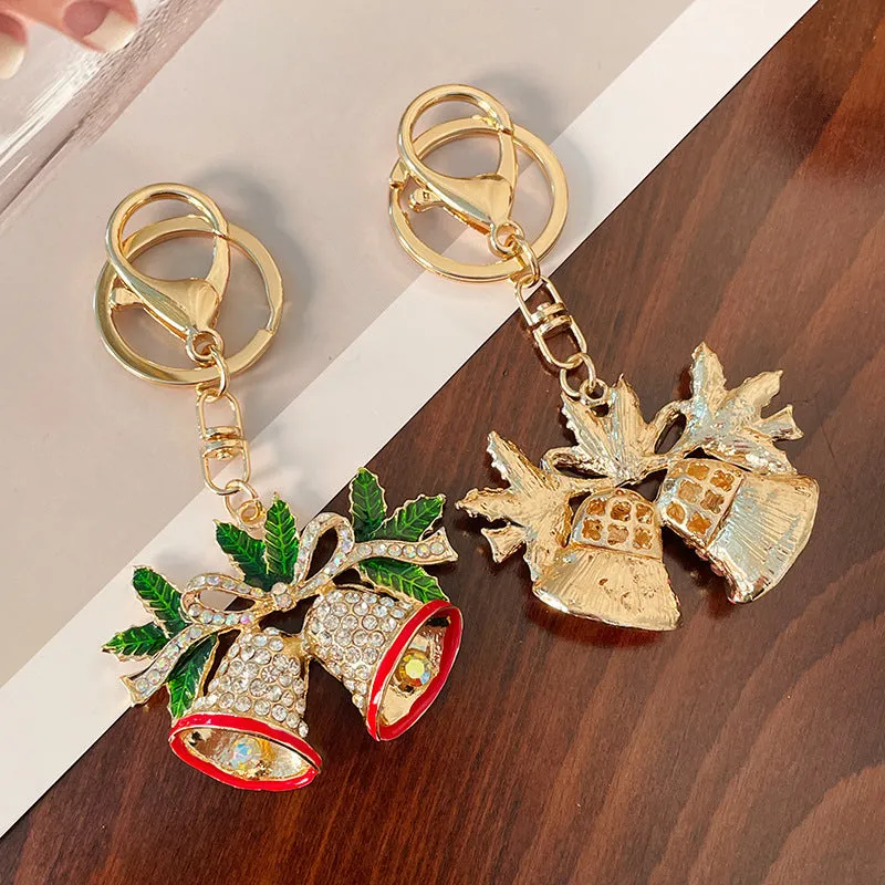 Christmas bell shaped metal keychain with diamond studded surface in champagne colour on white background