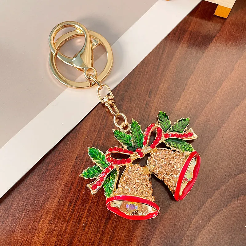 Christmas bell shaped metal keychain with diamond studded surface in champagne colour on white background