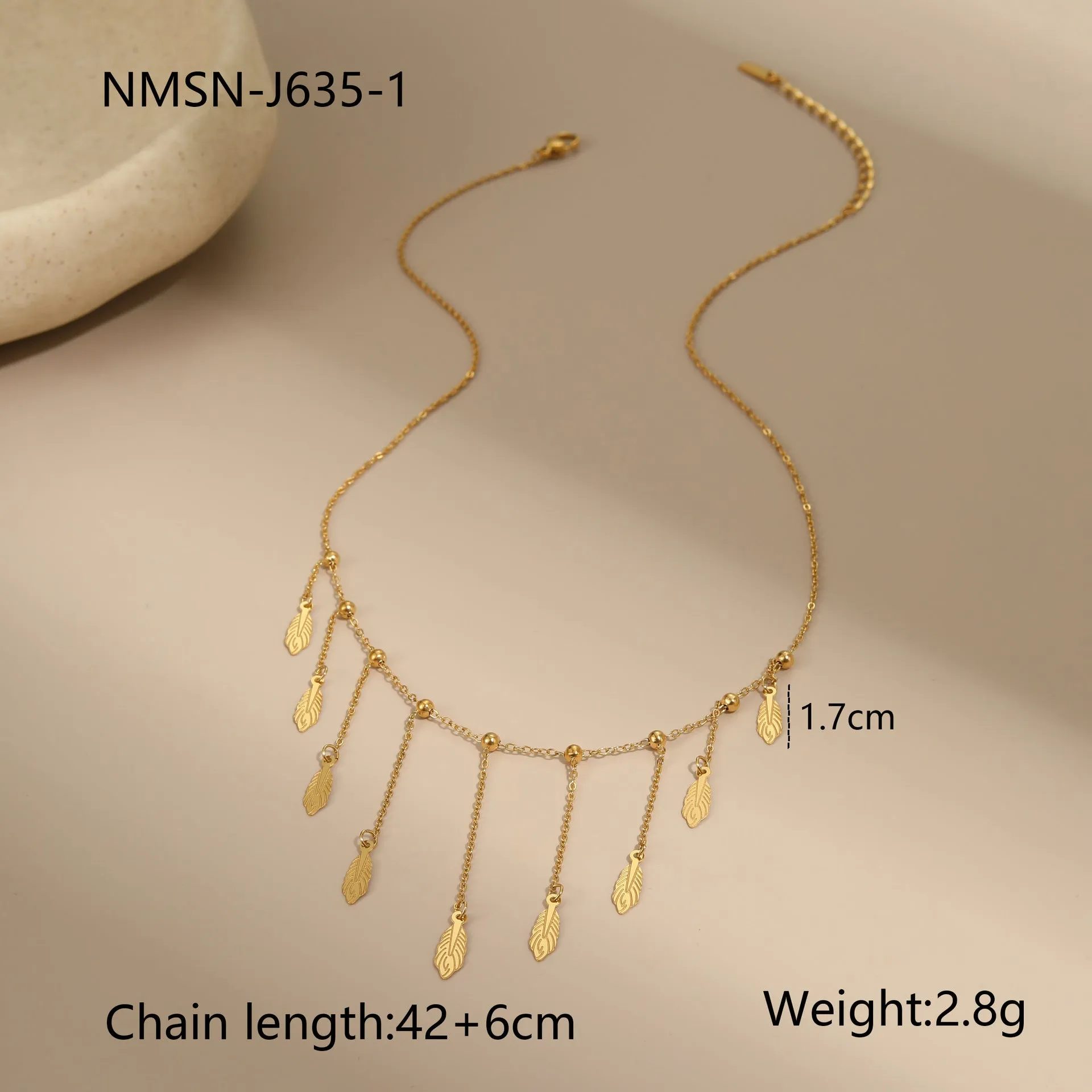 Gold clavicle chain necklace with geometric pendant and tassel detail on a woman's neckline
