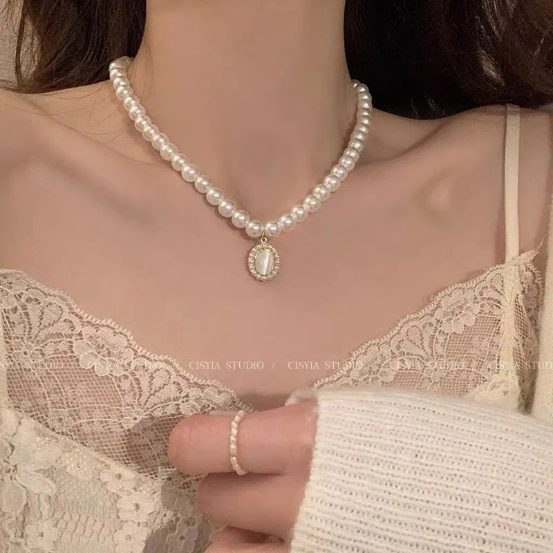Unisex magnetic sweater necklace with mother pearl shellfish pendant and organic glass setting on electroplated chain, available in multiple colours
