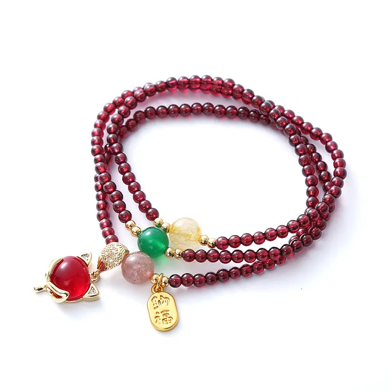 Purplish red adjustable rope bracelet with a detailed natural garnet fox charm.