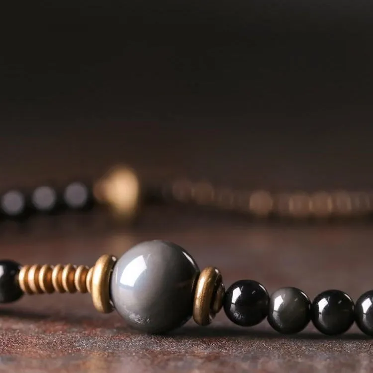 Black geometric patterned beaded bracelet with multi-layered natural materials design