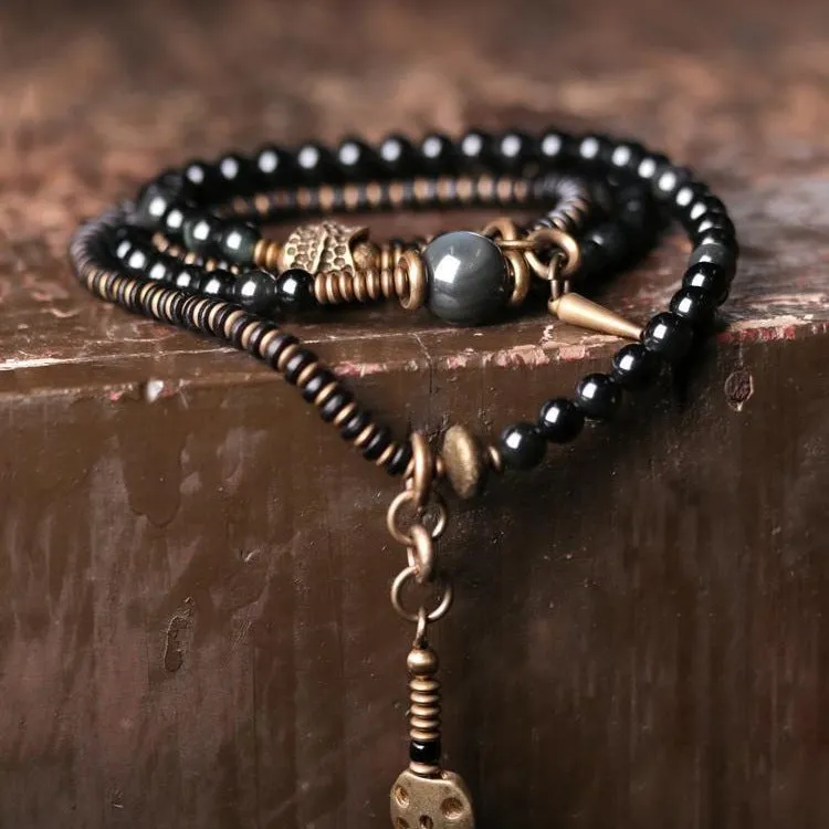 Black geometric patterned beaded bracelet with multi-layered natural materials design