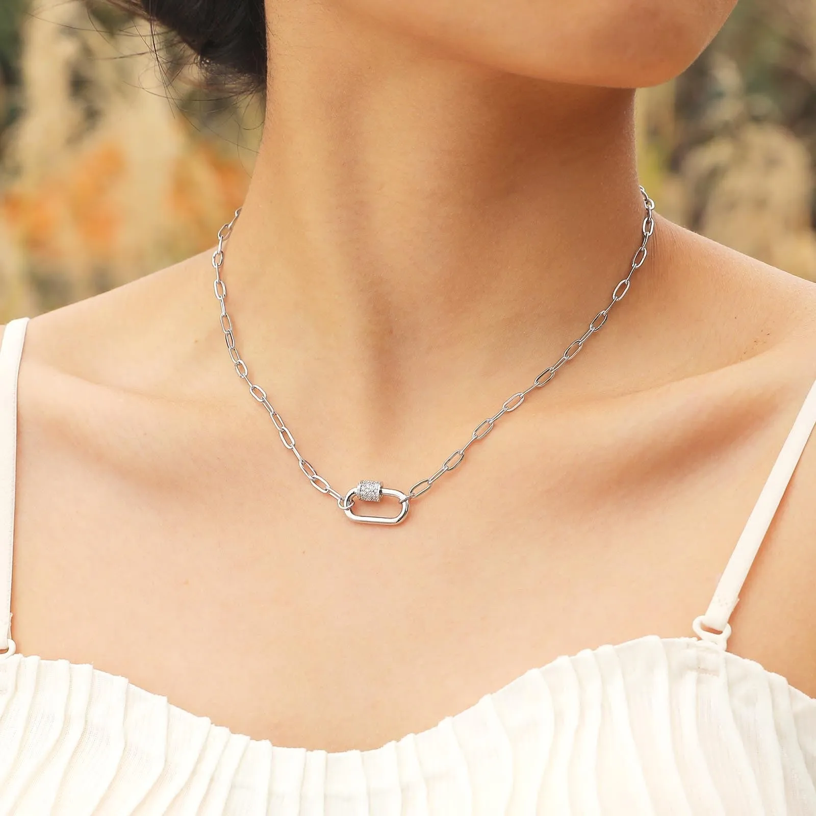 Gold electroplated stainless steel small square chain necklace with oval zircon pendant on a light background