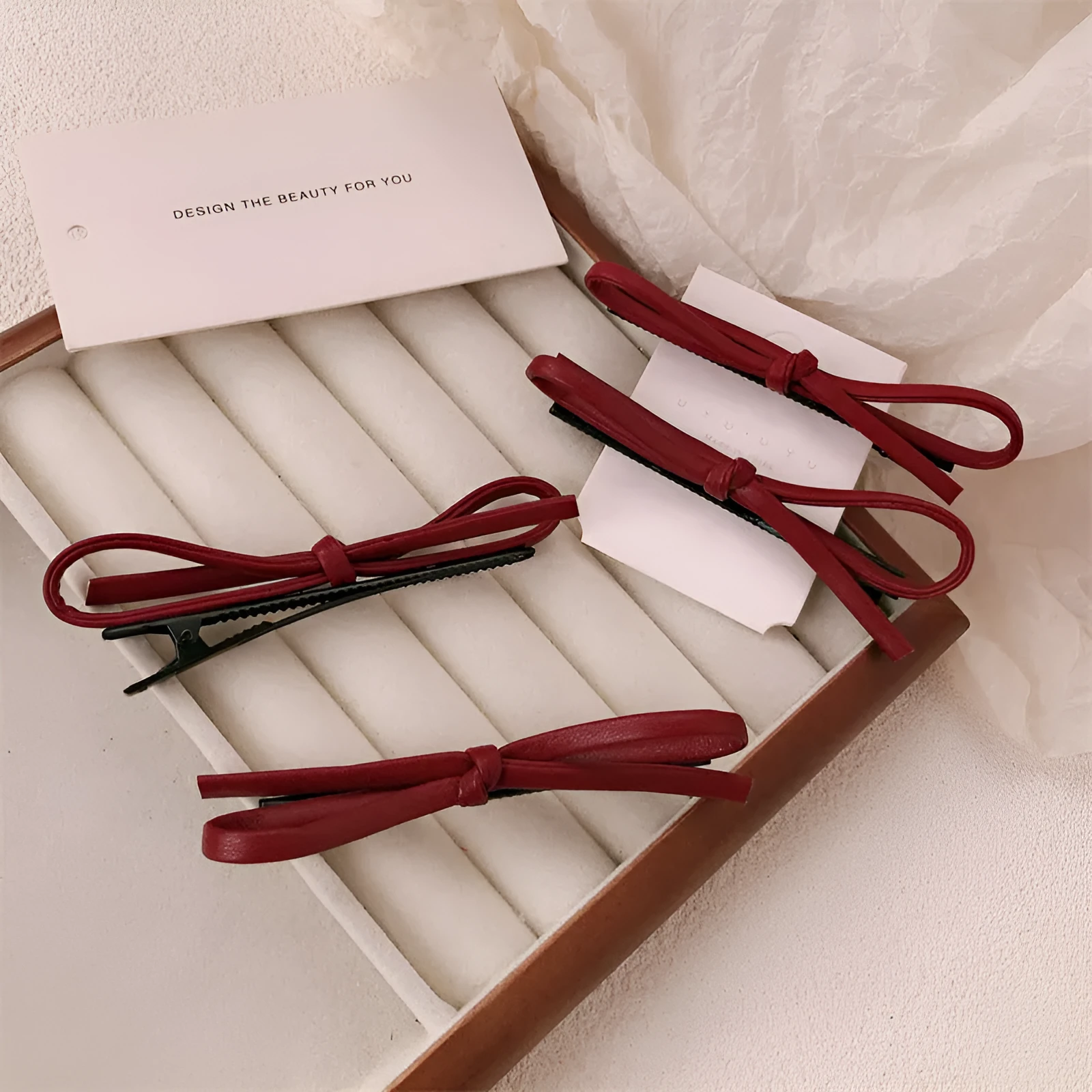 Wine red leather bow hair barrette on a white background.