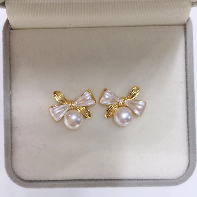 Two-tone bow pearl stud earrings in white or gray with flat circle shape