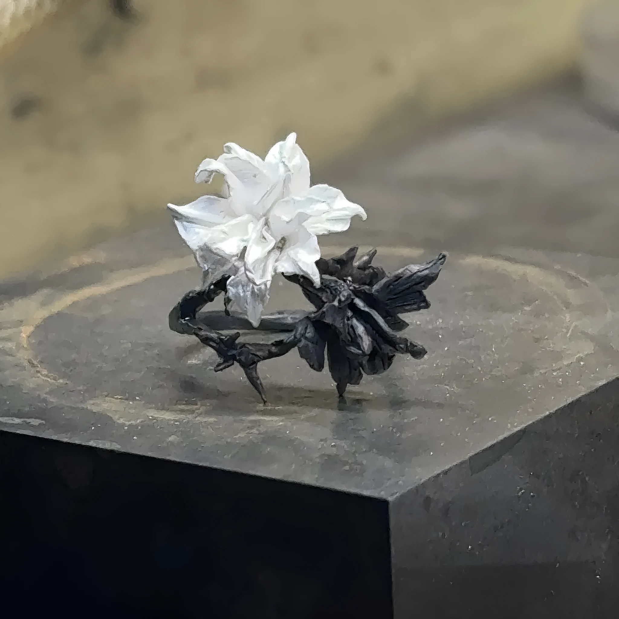 Open mouth copper ring with white and black colour separation and lily motif on a plain background