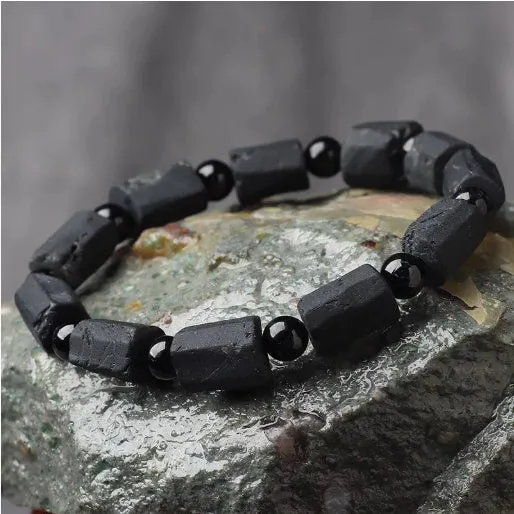 Black tourmaline rough stone bracelet on a wrist, showing natural texture and 10mm size