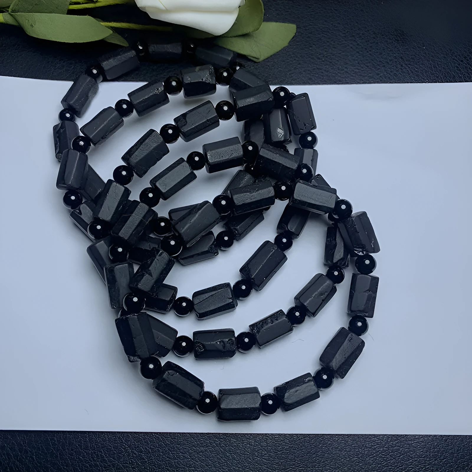 Black tourmaline rough stone bracelet on a wrist, showing natural texture and 10mm size