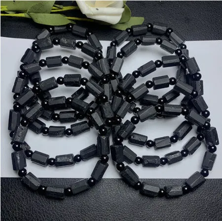 Black tourmaline rough stone bracelet on a wrist, showing natural texture and 10mm size