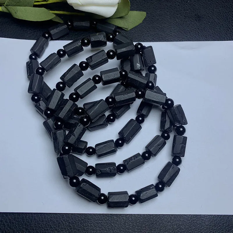 Black tourmaline rough stone bracelet on a wrist, showing natural texture and 10mm size