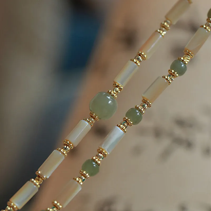 Simple women's bracelet made of round white Hetian jade beads on a wrist.
