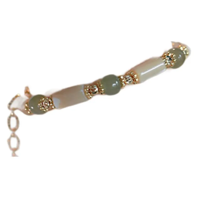 Simple women's bracelet made of round white Hetian jade beads on a wrist.
