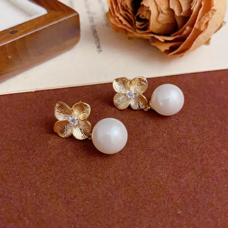 Pair of gold-plated copper earrings with metal petal design and faux pearl accents for women