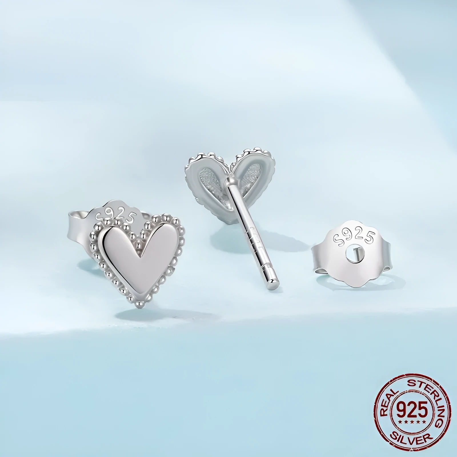 Simple S925 sterling silver heart-shaped ear studs with electroplated finish on a white background