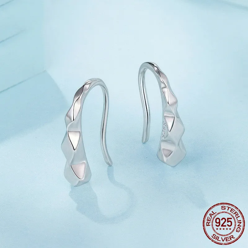 Close-up of S925 sterling silver rhombus earrings with diamond plaid pattern on a neutral background
